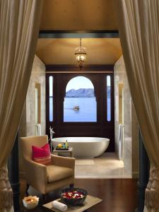乌代浦乌代普尔里拉皇宫酒店的带浴缸、椅子和窗户的浴室