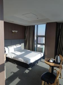 乌兰巴托J酒店的卧室配有1张床、1张桌子和1把椅子