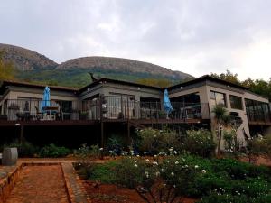 哈特比斯普特Magalies Mountain Lodge and Spa的前面有蓝色雨伞的房子