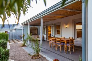 艾伯特王子镇Karoo Masterclass - Accommodation Prince Albert的庭院配有木桌和椅子