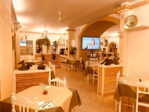 莱乌卡Albergo 2 Mari的一间带桌椅和电视的餐厅
