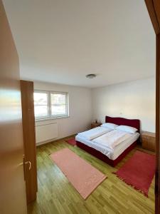 库普雷斯Kuća Vesna的一间卧室配有一张床和两张红色地毯