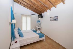 贝尼蔡斯Filoxenia Kirki Apartments by CorfuEscapes的一间卧室配有一张带蓝色枕头的床