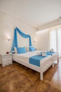 贝尼蔡斯Filoxenia Kirki Apartments by CorfuEscapes的一间卧室设有两张带蓝色窗帘的大床