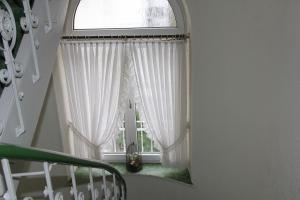 曼海姆科法尔斯图本酒店的一个带窗户的楼梯,配有白色窗帘