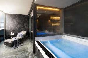 勒赫尔恩巴赫Wellness- & Sporthotel Jagdhof的一个带大窗户的浴室内的一个大型游泳池