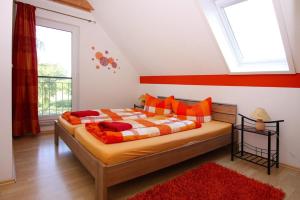NeuendorfDoppelhaushälfte mit Blick auf das Wasser am Hafen von Neuendorf的一间卧室配有一张带橙色和白色床单的大床
