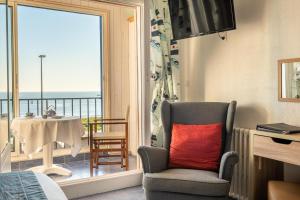 欧迪耶讷海滩酒店餐厅的一间带椅子和一张桌子的窗户的房间