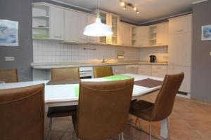 马尔肖Apartment, Malchow的一间带桌椅的厨房和一间带白色橱柜的厨房