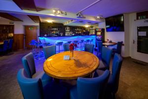林根贝格Boutique Hotel & Restaurant Bären Ringgenberg的一间带木桌和蓝色椅子的用餐室
