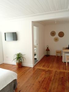 奥德米拉Casa da Umbria的卧室设有白色墙壁和木地板