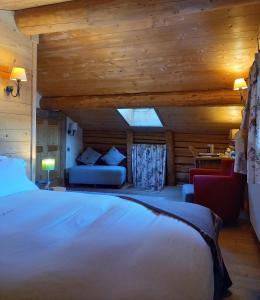 欧特吕斯La Ferme du Chozal, Chalet de tradition的一间卧室配有一张床和一个沙发