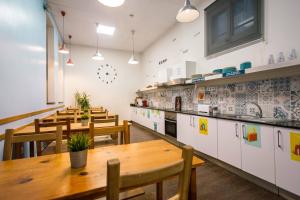 巴塞罗那360 Hostel Borne的一间带木桌椅的餐厅和一间厨房