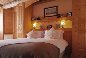 欧特吕斯La Ferme du Chozal, Chalet de tradition的卧室配有带白色枕头的大床