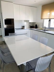 纳扎雷Peter Townhouse的白色的厨房配有白色的桌子和椅子
