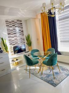 鲍里斯皮尔DeLight Apartments的一间设有玻璃桌和绿色椅子的用餐室