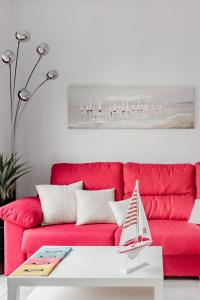 阿利坎特Lujoso piso en Casco Histórico,Playa del Postiguet的客厅里一张红色的沙发,配有桌子