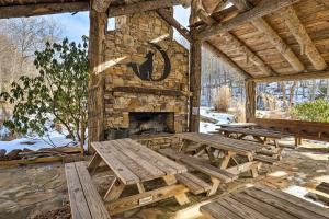 SwissRustic Mars Hill Cabin 20 Miles to Asheville!的一座石头建筑,设有野餐桌和壁炉