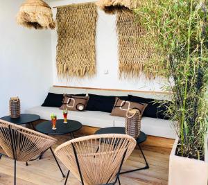 滨海阿热莱斯Le S的庭院配有2张桌子和椅子以及沙发。