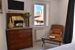 陶尔米纳Taormina Apartments "casa di Anna"的一间卧室配有梳妆台、椅子和镜子