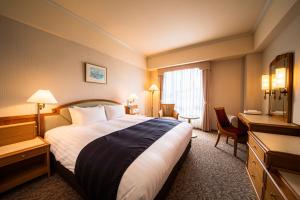 吴市吴阪急酒店的酒店客房设有一张大床和一张书桌。