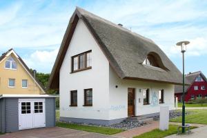 维埃雷格Ferienhaus Poseidon mit Meerblick am Breetzer Bodden in Vieregge的白色的茅草屋顶房屋