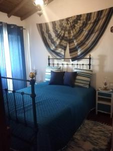 São Pedro do CorvalCasa da Avó Rita的一间卧室配有蓝色的床和蓝色窗帘