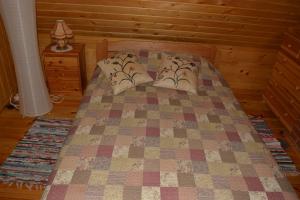 UpesgrīvaHoliday Home Bērzlejas的卧室内的一张带被子和枕头的床