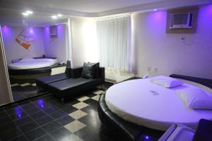 萨尔瓦多Piramide Stella Maris Adults Only的一间设有两张床的房间和一间紫色灯的房间