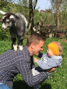 LonevågSkjerping gårdshus,的肩上拿着山羊抱着婴儿的男人