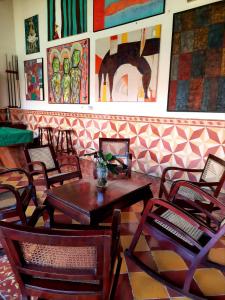 莱昂Hotel La Posada del Doctor的餐厅设有桌椅,墙上挂有绘画作品