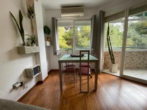 多列毛利诺斯APARTAMENTO PINAR de MONTEMAR的客房设有一张桌子、两把椅子和一个窗户。