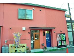洞爷湖Guest House HiDE - Vacation STAY 64843v的前面有标志的红色建筑