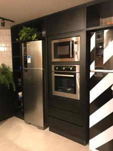 维多利亚Artsy Vitoria Hostel的厨房配有冰箱和微波炉。