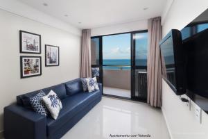 纳塔尔Apto 2Q com varanda no Ed Maximum Home的客厅设有蓝色的沙发和大窗户