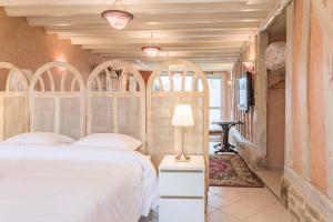 圣玛丽桥Le RUBIS - Confort - Proche Mag Outlet Troyes - Parking gratuit的卧室配有一张白色床和拱形床头板