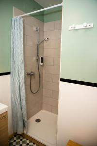 莱齐尼昂科尔比埃Cosy Green Clim Wifi Centre ville 2 pers的带淋浴和浴帘的浴室