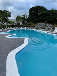 安东尼奥港Jamaica Palace Hotel的一座蓝色海水和椅子的大型游泳池