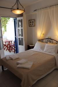 阿莫尔戈斯Pension Ilias - Chora Amorgos的一间卧室配有一张大床和毛巾