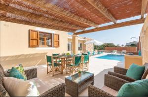 卡拉恩·布拉內斯Villas Sa Ferradura的一个带桌椅的庭院和一个游泳池