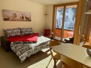 弗利姆斯Selva Mountain Apartment的一间卧室配有一张床、一张桌子和一个窗户。