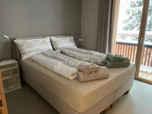 弗利姆斯Selva Mountain Apartment的一张带两条毛巾的床和窗户