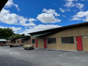 蒂库伊蒂Waitomo Lodge的一座设有红色门的建筑和停车场