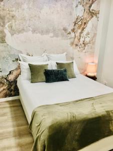 阿威罗Marquês d'Aveiro Suite的卧室配有一张带四个枕头的大型白色床