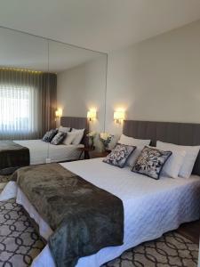 波尔图Trindade Apartments的酒店客房,设有两张床和镜子