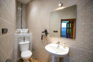 非斯Riad Soultana的一间带卫生间、水槽和镜子的浴室