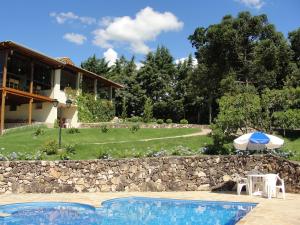 阿瓜斯迪林多亚绿山旅馆的一个带遮阳伞和房子的游泳池