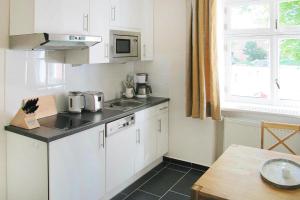 GarzMansion in Garz with garden的厨房配有白色橱柜、水槽和窗户。