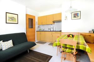 西兰德罗Apartment in Schlanders with terrace的厨房以及带桌子和沙发的客厅。