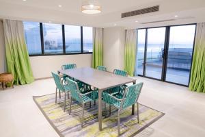 马尼拉Lime Resort Manila的一间配备有绿色椅子和桌子的用餐室